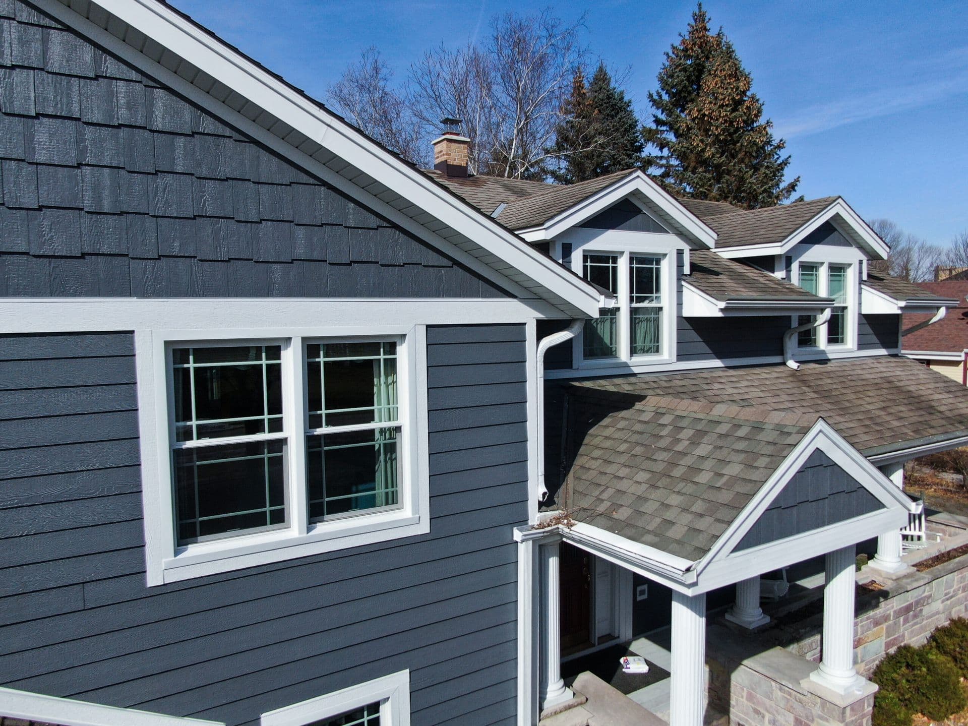 A house with new blue-gray LP Smart Siding and white trim.